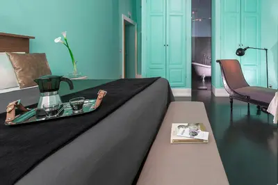 a bedroom with a bed with a tray with a tea set on it at Daniele Manin Roma in Rome