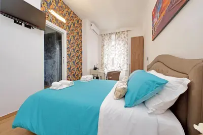 a bedroom with a blue bed with white pillows at Misa Guest House San Lorenzo in Rome
