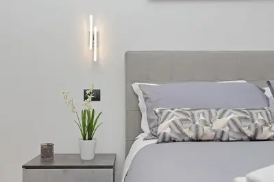 a white bed with a pillow and a table with a plant at Misa Guest House San Lorenzo in Rome