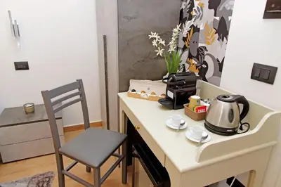 a table with a tea kettle and a chair at Misa Guest House San Lorenzo in Rome