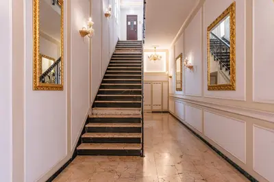 a hallway with stairs and paintings on the walls at Decimo Meridio- At Spanish Steps- in Rome