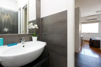 a bathroom with a white sink and a mirror at Roma Trastevere Relais Guest House in Rome