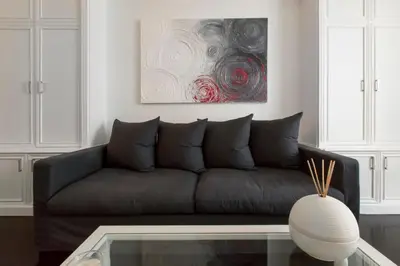 a living room with a couch and a painting at Xenia Guest House in Rome