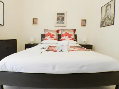 a bedroom with a large white bed with two pillows at Re di Roma House in Rome