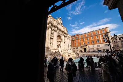 a group of people walking around the trevi fountain at Fontana di Trevi sweet apartment in Rome