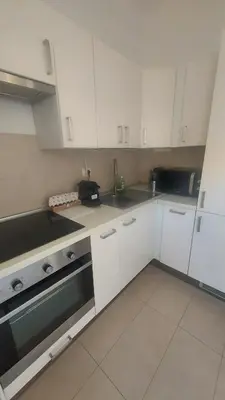 a kitchen with white cabinets and a sink at Houses Donatello & Tiziano Roma in Rome