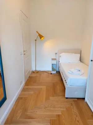 a bedroom with a bed and a lamp on a wooden floor at casa gemelli vaticano roma in Rome