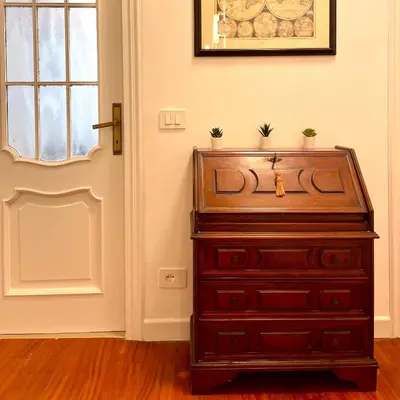 a wooden dresser in a room with a door at Lazy Time Apartment in Rome