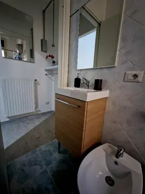 a bathroom with a sink and a mirror and a toilet at Tiburtina Keys - Roma in Rome