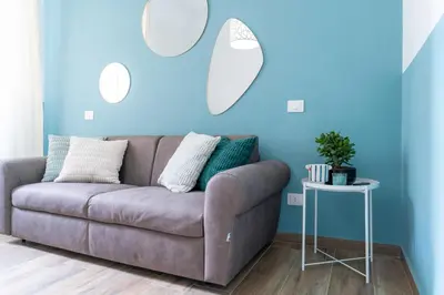 a couch in a living room with blue walls at Colosseo Home San Giovanni in Rome