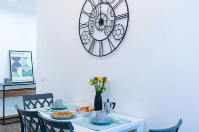 a dining room table with a clock on the wall at Colosseo Home San Giovanni in Rome