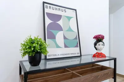 a shelf with a picture and a vase of flowers at Colosseo Home San Giovanni in Rome