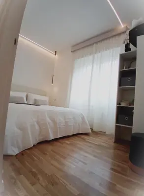 a bedroom with a white bed and a wooden floor at ad vatican luxury apartment in Rome