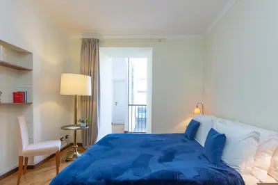 a bedroom with a blue bed and a chair at Amazing Elegant Jewish Ghetto in Rome