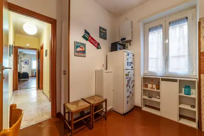 a kitchen with a refrigerator and a table and a chair at San Paolo Apartment - Charme Holidays in Rome