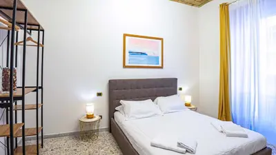 a bedroom with a bed with white sheets and two lamps at Candia Delizioso Appartamento vicino al Vaticano in Rome