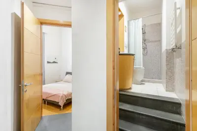 a bedroom with a bed and a door leading to a bathroom at Beige luxury apartment Rome in Rome