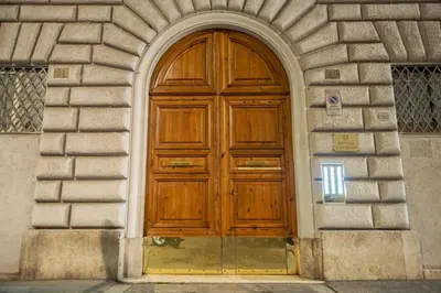 a wooden door in a building with an arch at Minerva Boutique Residence in Rome
