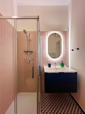 a bathroom with a sink and a shower with a mirror at MuMo Home Pigneto in Rome
