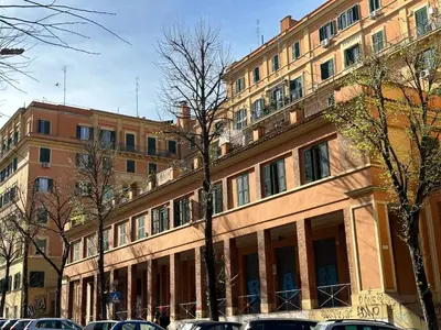 a large building with cars parked in front of it at MuMo Home Pigneto in Rome