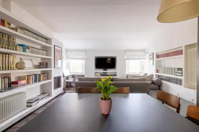a living room with a table and a couch and a tv at Farnesi Terrace Penthouse in Rome