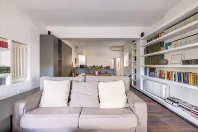 a living room with a couch and bookshelves at Farnesi Terrace Penthouse in Rome