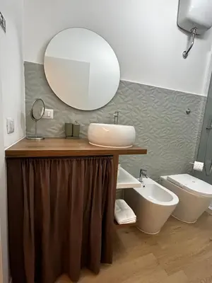a bathroom with a sink and a mirror and a toilet at flaTminio modern & nice apartment in Rome