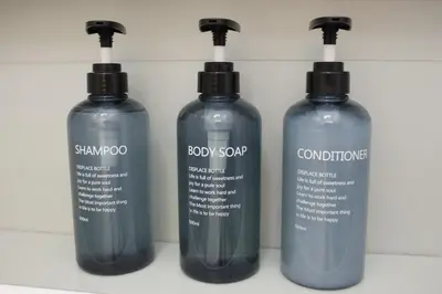 three bottles of shampoo and conditioner on a wall at flaTminio modern & nice apartment in Rome