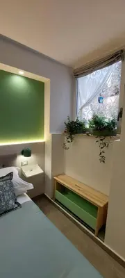 a bedroom with a bed and a window with plants on it at The Golden Pyramid in Rome
