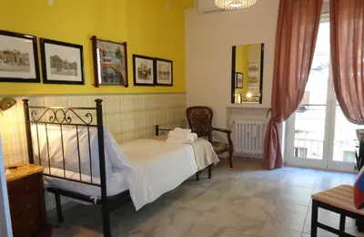 a bedroom with a bed in a room with yellow walls at Happy Home Piramide Cestia Lussuoso Unico Esclusivo a Roma in Rome