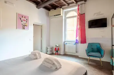 a bedroom with a bed and a chair and a window at maison pelliccia in Rome