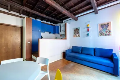 a living room with a blue couch and a kitchen at maison pelliccia in Rome