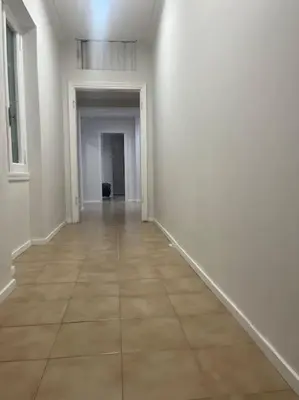 an empty hallway with white walls and a tile floor at Apartment V12 in Rome