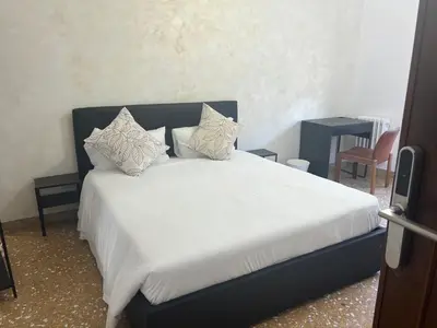 a bedroom with a bed with white sheets and pillows at Valentina House in Rome