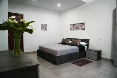 a bedroom with a bed and a vase of flowers at Ale Apartment in Rome