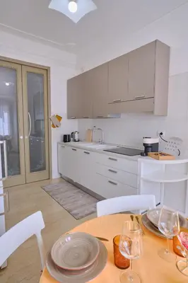a kitchen with a table and chairs and a kitchen with white cabinets at MAJOR DOMUS 501 in Rome