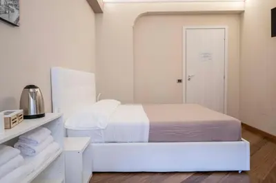 a white room with a bed and a shelf with towels at Le stanze sui musei vaticani in Rome
