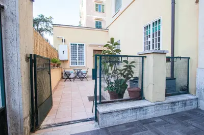 a gate with a potted plant next to a building at ODESCALCHI LOFT in Rome
