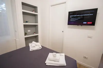 a room with a bed with towels and a flat screen tv at ODESCALCHI LOFT in Rome