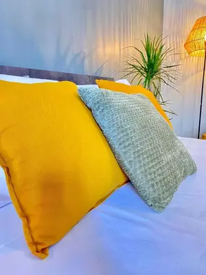 a bed with yellow and blue pillows on it at Bright apartment near San Pietro in Rome