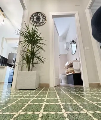 a room with a clock on the wall and a plant at Bright apartment near San Pietro in Rome