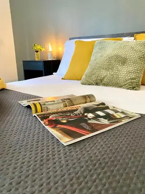 a magazine laying on a bed in a bedroom at Bright apartment near San Pietro in Rome
