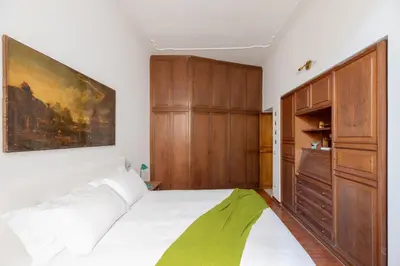 a bedroom with a white bed and wooden cabinets at iFlat Elegant 3 bedroom apt near the Pantheon in Rome