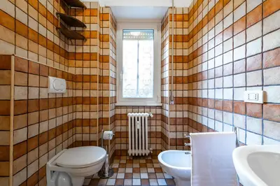 a bathroom with a toilet and a sink and a window at Leoncavallo Retreat in Rome