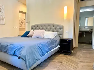 a bedroom with a large bed with a blue comforter at Ghirlanda House in Rome