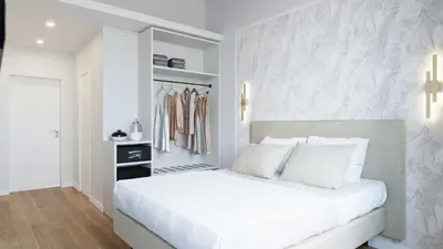 a bedroom with a white bed and a closet at Maison Romana Trastevere Suites in Rome