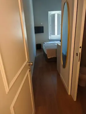 a room with a door and a bed and a mirror at Maison Romana Trastevere Suites in Rome