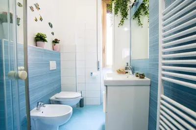a blue bathroom with a toilet and a sink at Datama House in Rome