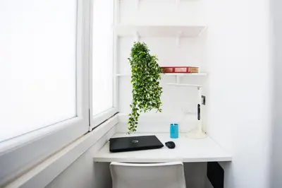 a white desk with a laptop and a plant at Datama House in Rome
