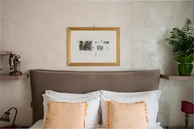 a bed with white pillows and a picture on the wall at Datama House in Rome